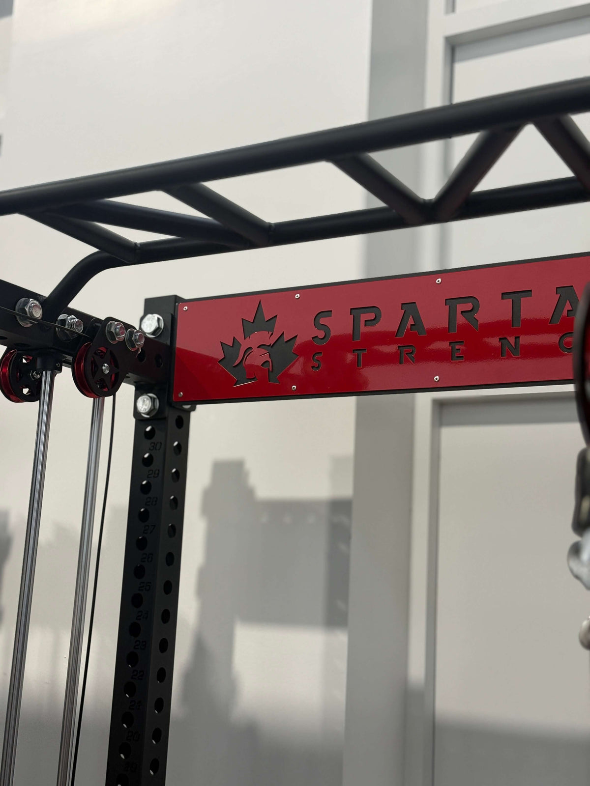 Spartaks Strength KB2402 Functional Squat Rack (3”×3”, 9-Gauge Steel) frame with dual-pulley system close-up.