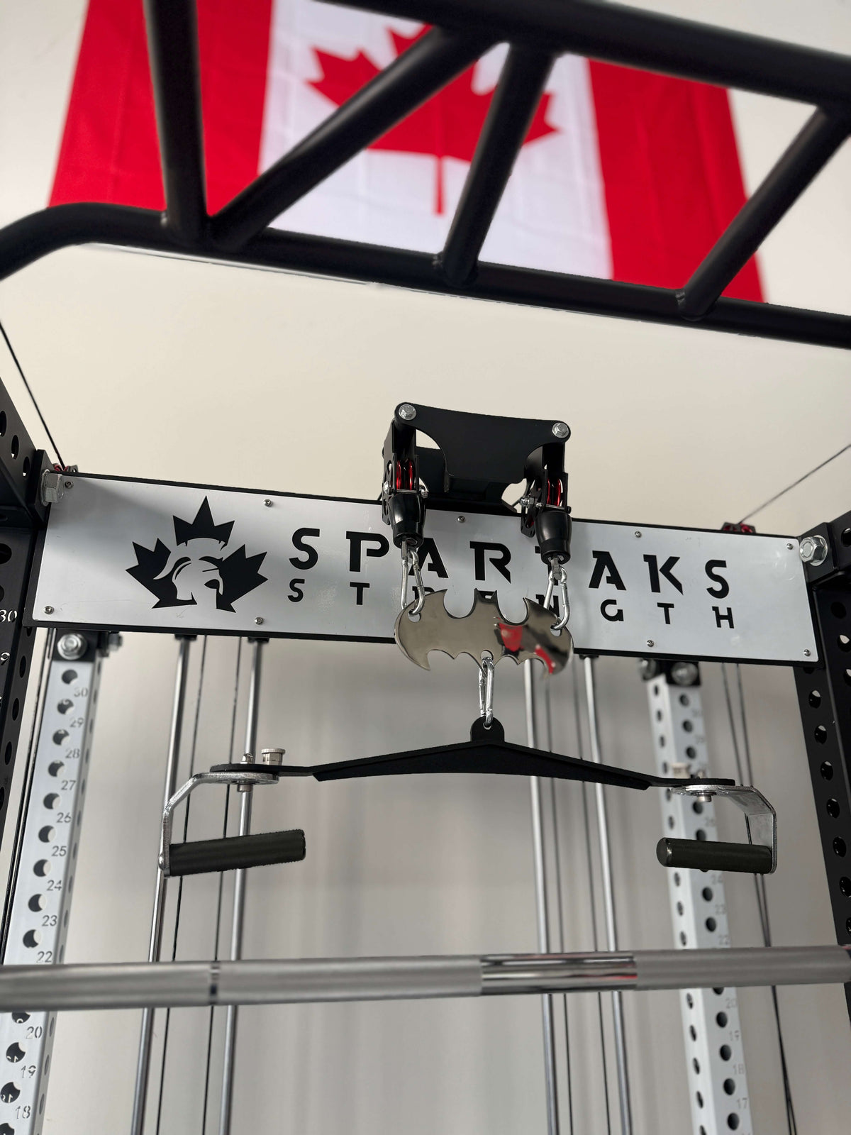 Spartaks Strength KB2406 6-Post Full Rack Functional Trainer (3”×3”, 9-Gauge Steel) components with Canadian flag in background.