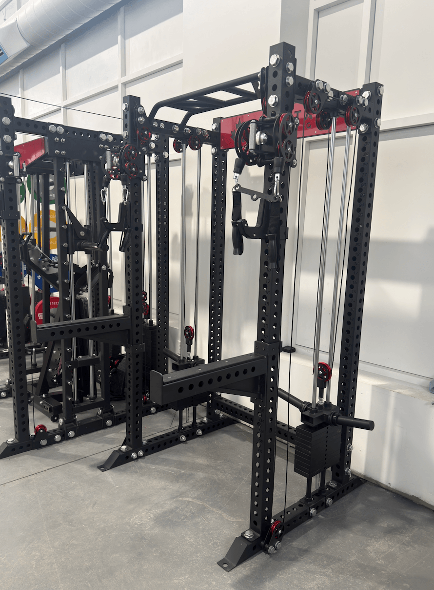 Spartaks Strength KB2402 Functional Squat Rack (3”×3”, 9-Gauge Steel) in a gym setting with dual-pulley system.