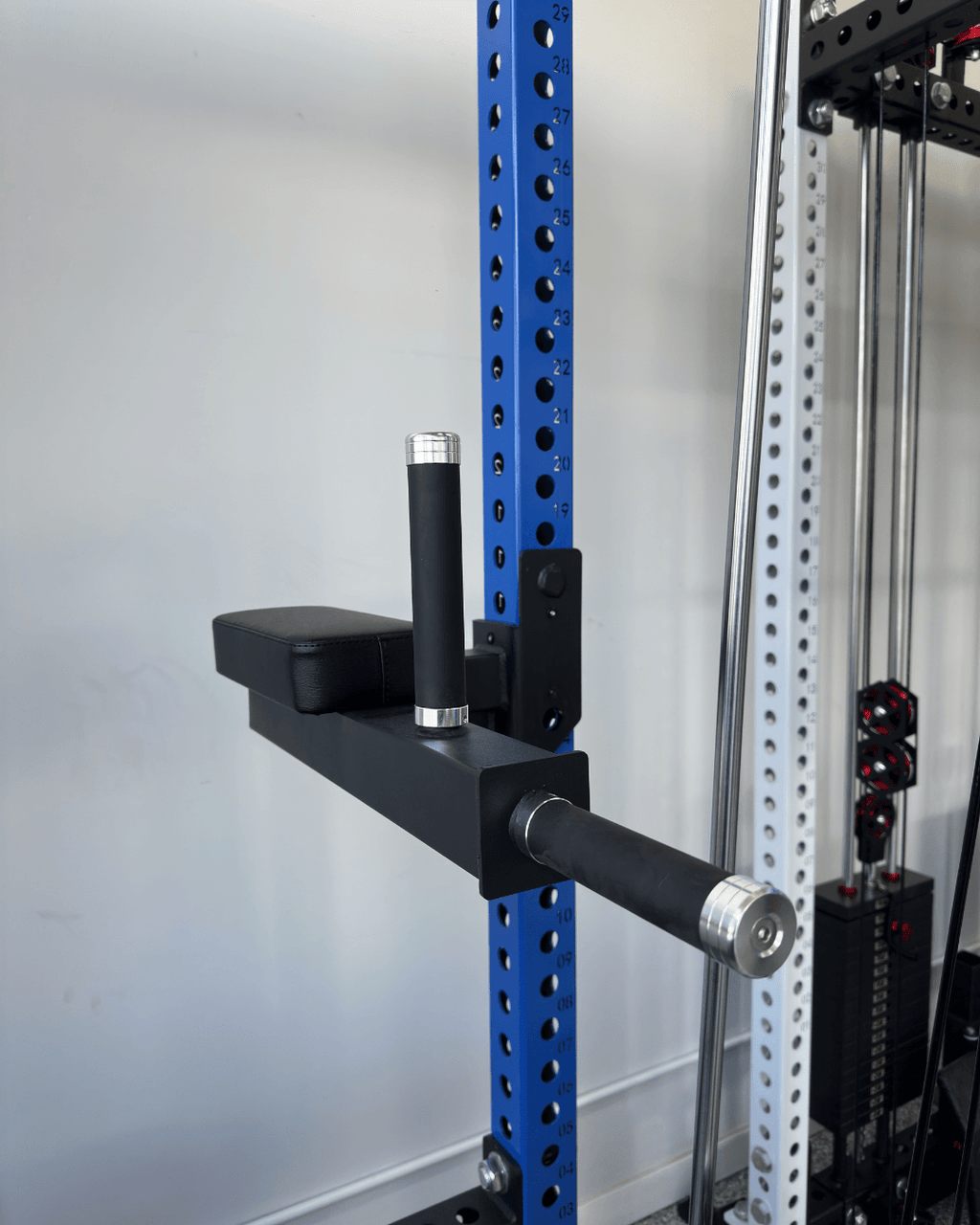 Spartaks Strength Leg Raise and Dip Combo Rack Attachment on a power rack for strength training.