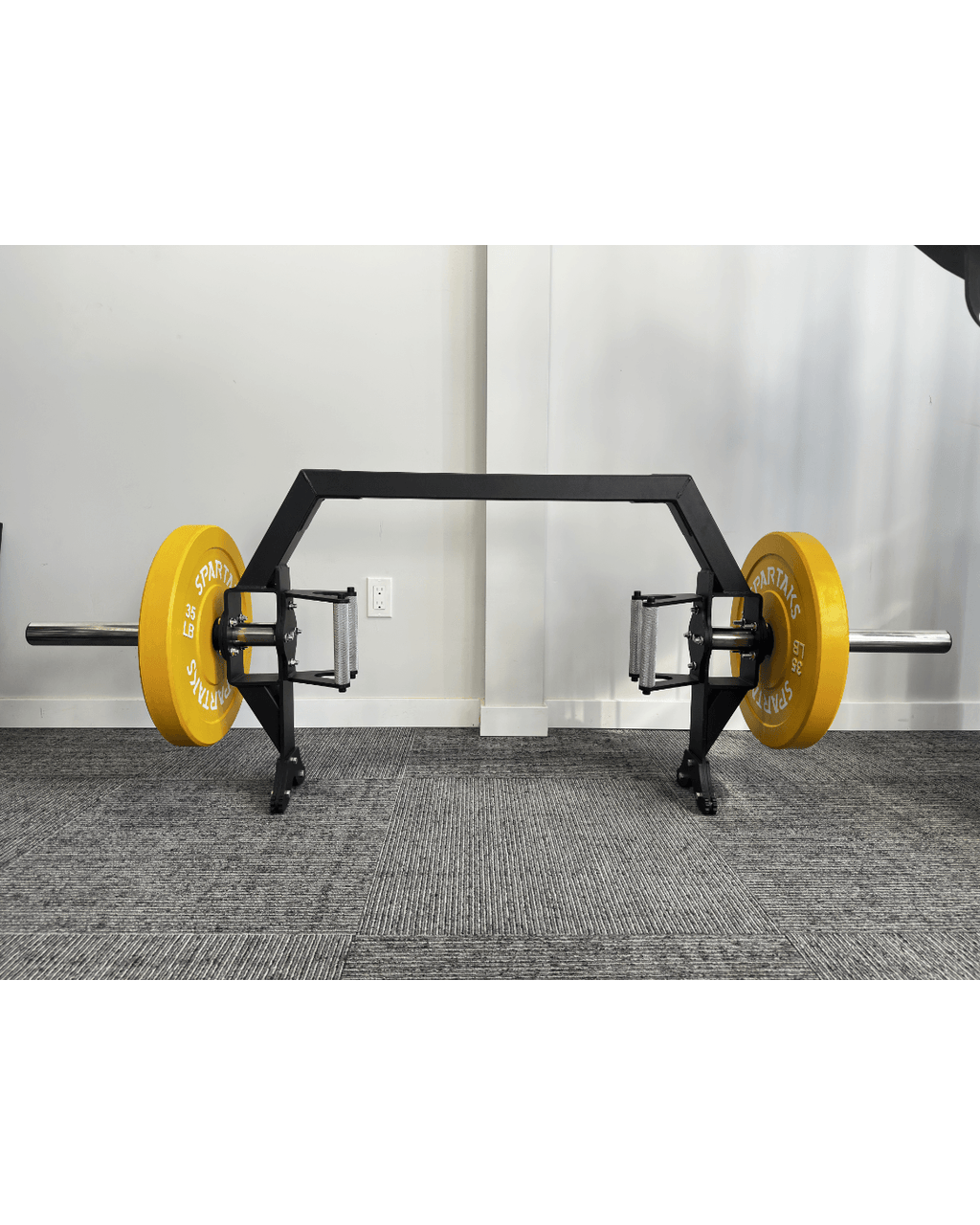 Spartaks Strength Trap Bar with yellow weight plates, designed for versatile strength training and deadlifts.