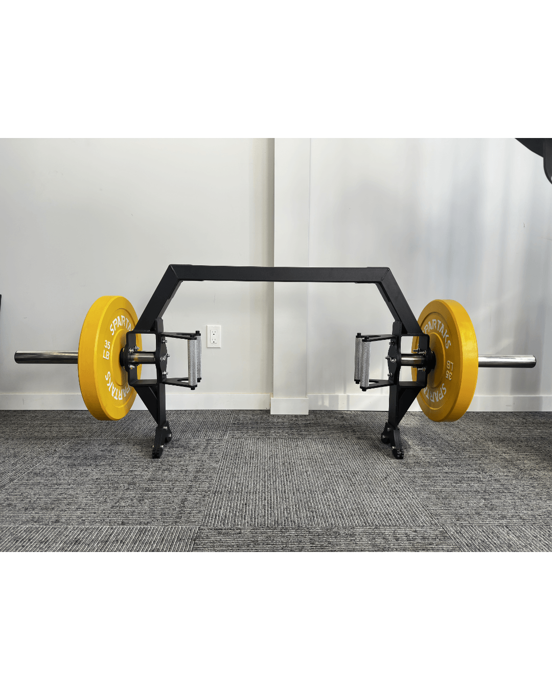 Spartaks Strength Trap Bar with yellow weight plates, designed for versatile strength training and deadlifts.