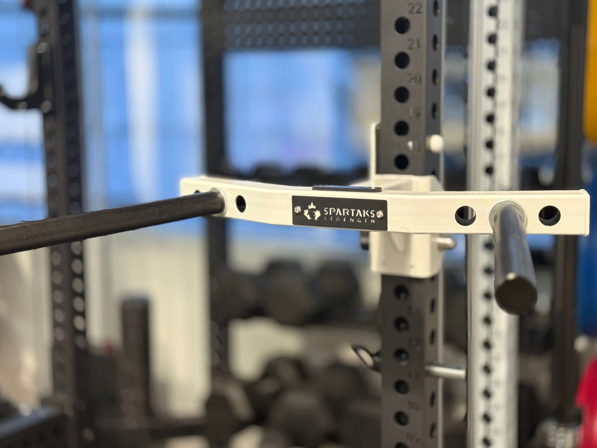 Close-up of Spartaks Strength Y-Shape One Piece Dip Station (Adjustable Width) with weight bar attachment in gym.